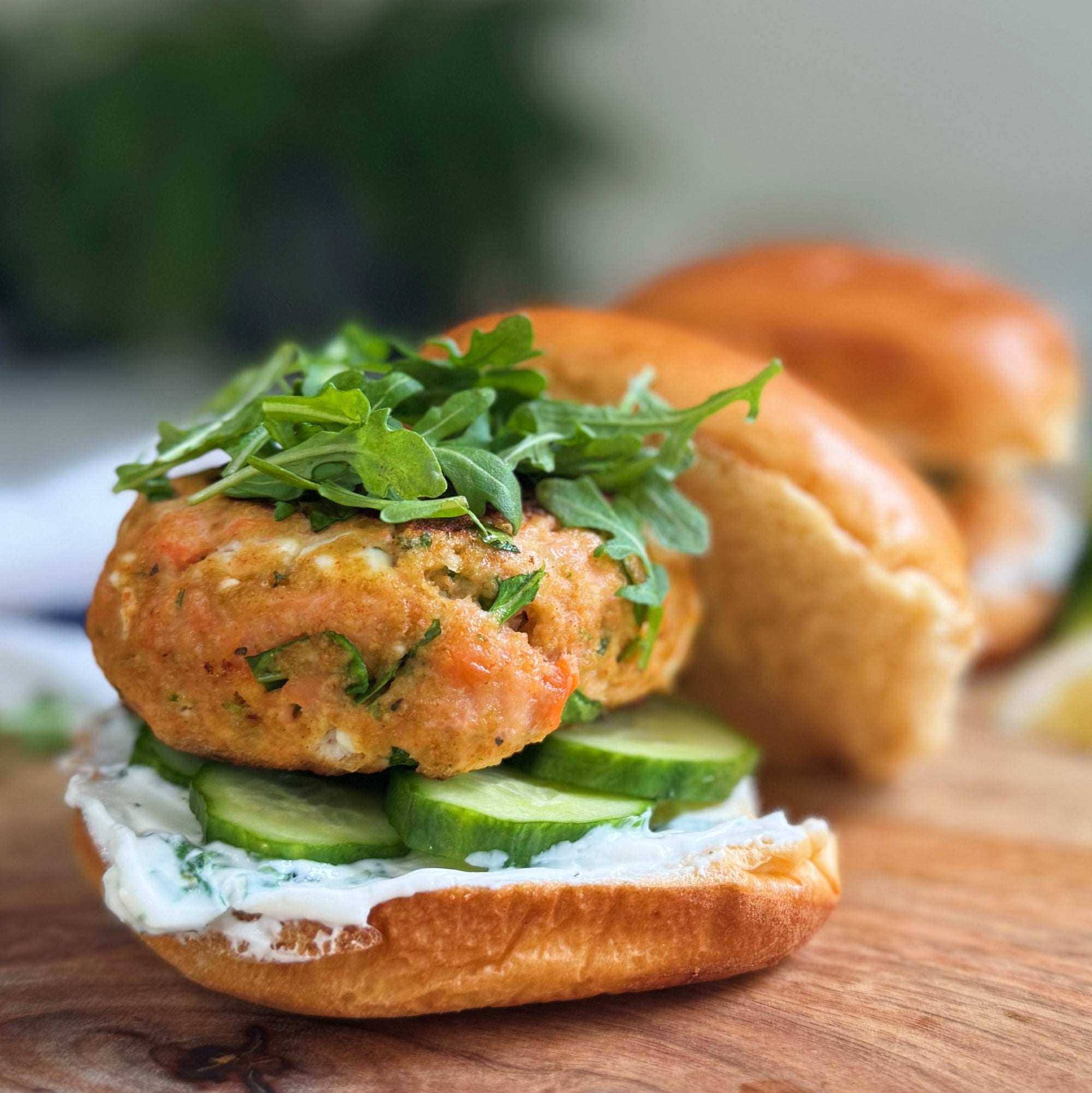 Mediterranean salmon burger made with wild-caught ground coho from Premier Catch and served on a brioche bun with arugula and pickles