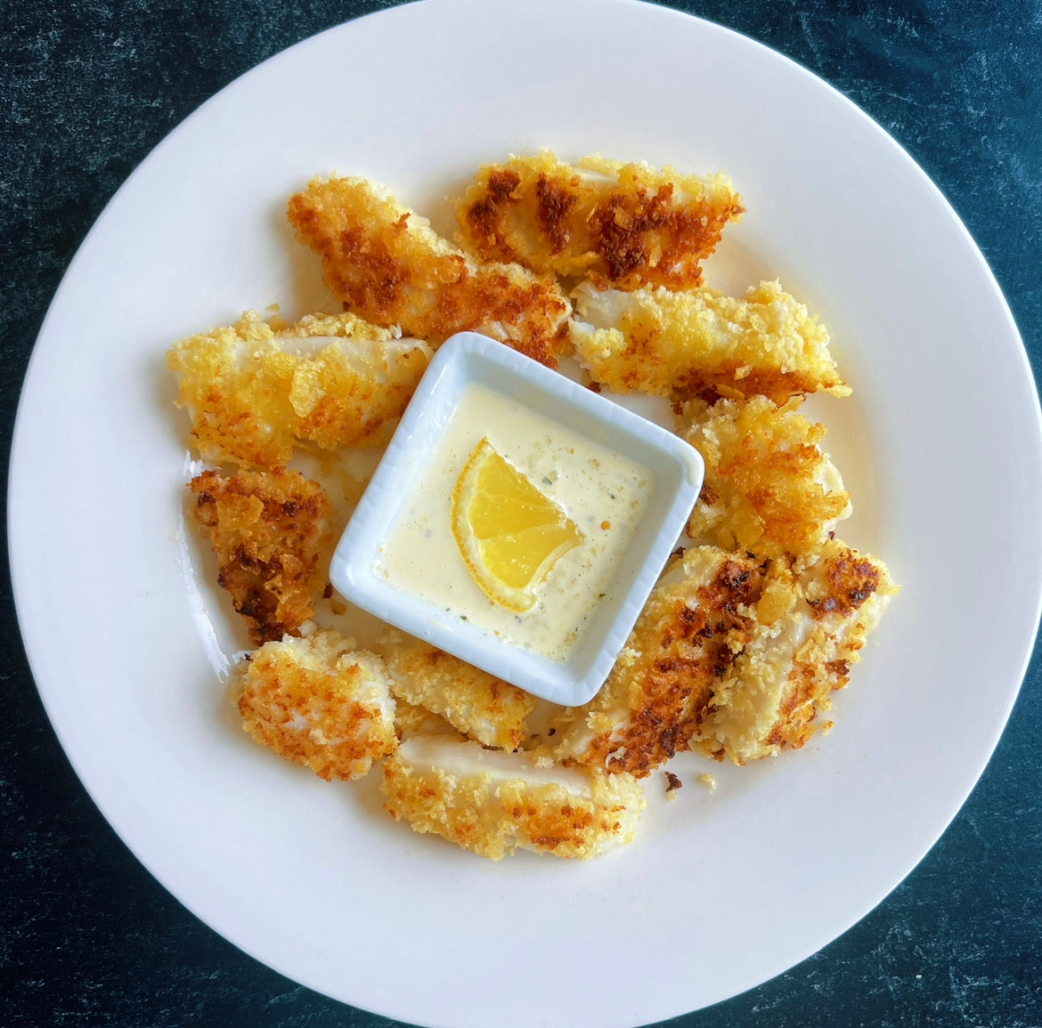 Wild caught Pacific potato chip crusted halibut sticks with lemon garlic aioli served on a plate for lunch or dinner