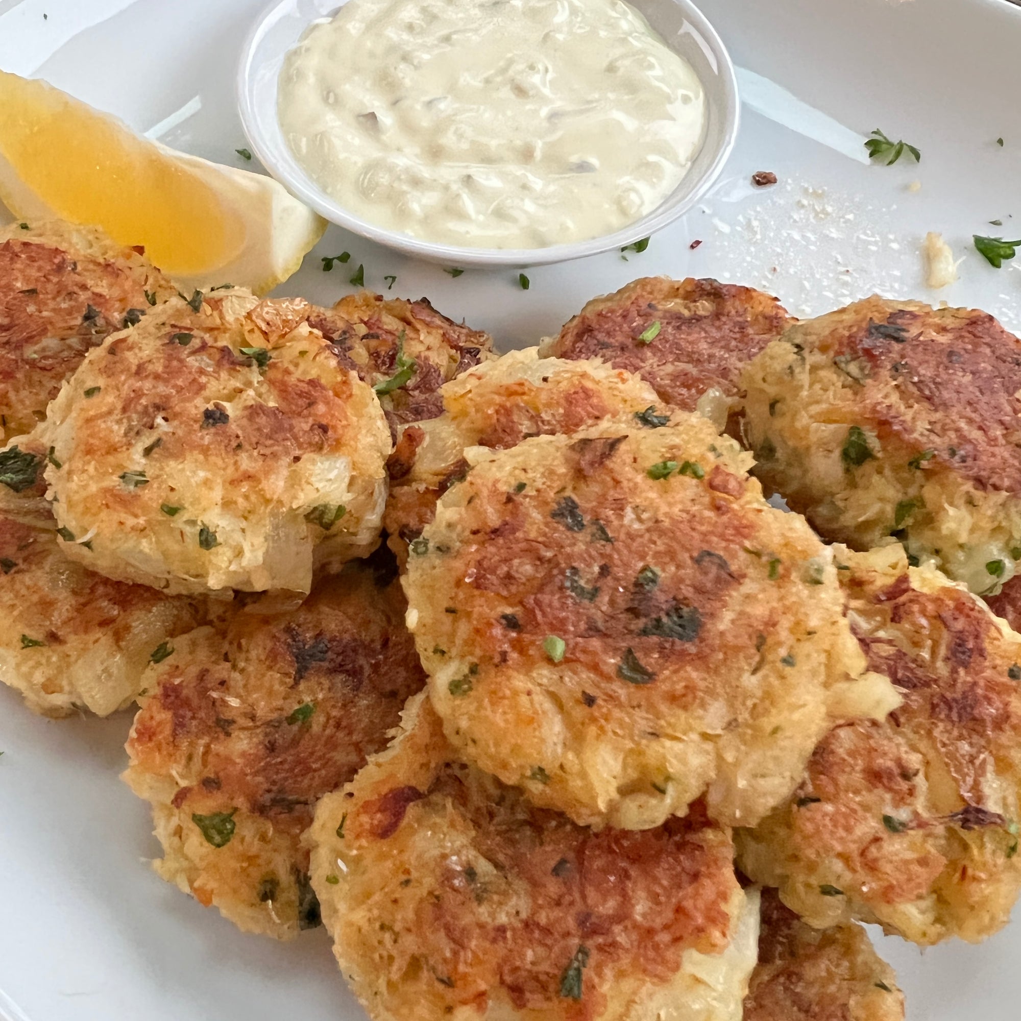 The best crab cakes made with Dungeness crab meat from Premier Catch and served on a plate with homemade tarter sauce