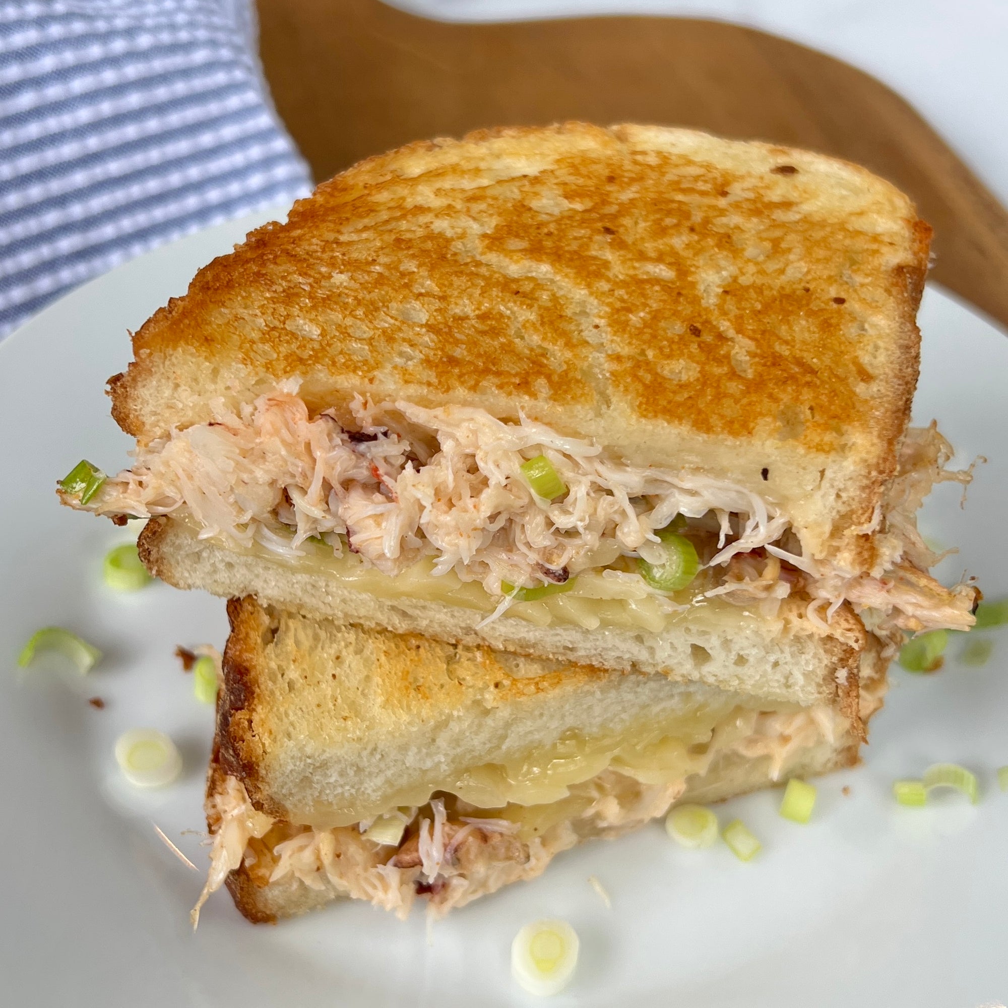 Dungeness crab meat grilled cheese sandwich on a plate.