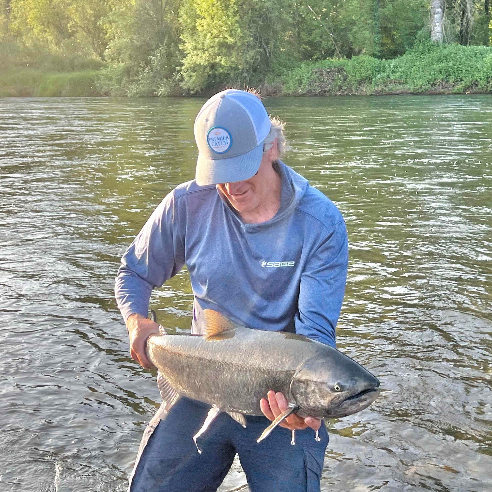 PC Trucker Hat with man carrying caught king salmon