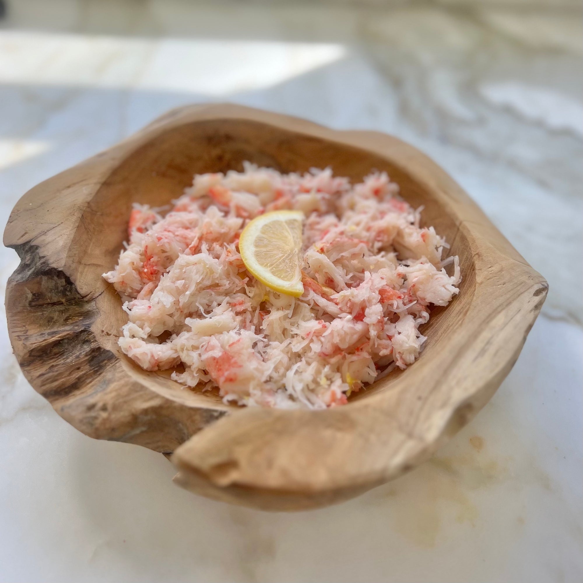 Shredded snow crab meat in a wooden bowl