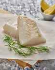 Wild cod on a wooden platter before cooking